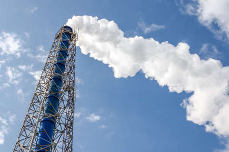 Smokestack and steam on blue sky backgroundの写真素材