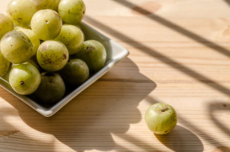 Indian Gooseberry: berry of high vitamin-c on the wooden background