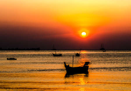 Blurred of silhouette boat on the ocean and sunset backgroundの写真素材