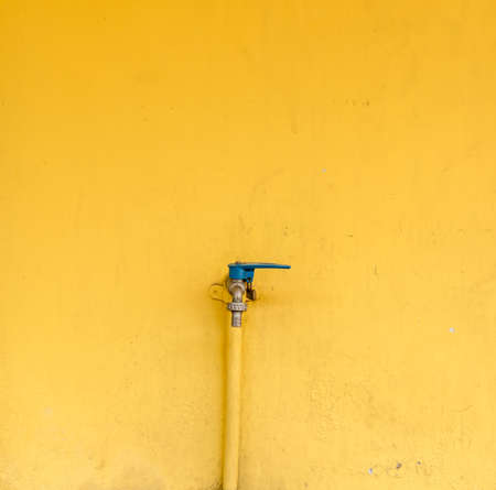 Faucet for water on the yellow wallの写真素材