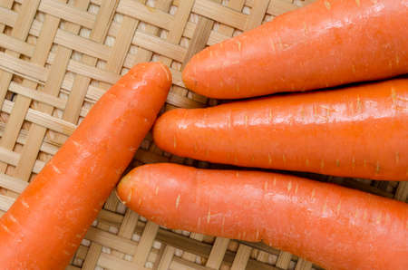 Fresh carrots on the bamboo basket on the wooden table horizontal