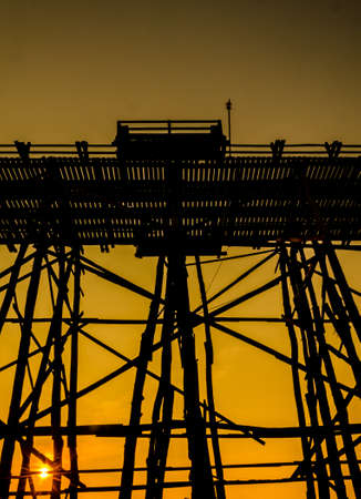 Silhouetted bridge at sunset, Sangkla, Kanjanaburi Province, Thailandの写真素材