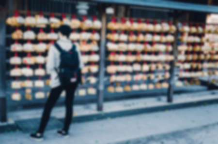 Blurred background. Blurred woman waiting in Shinto temple. Vintage toned photo.の写真素材