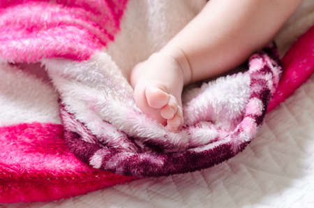 Asian newborn baby's foot on the bedの写真素材