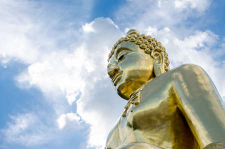 Gold color Statue in thai temple over blue skyの写真素材