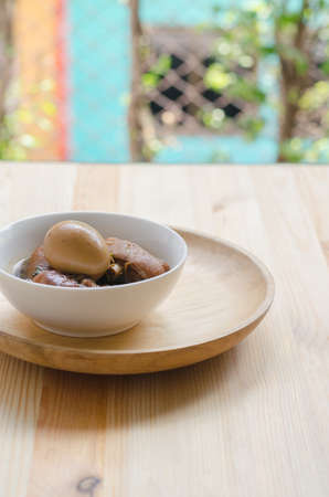 Egg and pork in brown sauce on wooden background, Thai Cuisine