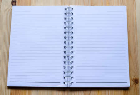 Note book paper on wooden background