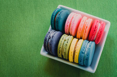 Sweet magaroon on wooden table in retro cafe, vintage tone filterの写真素材