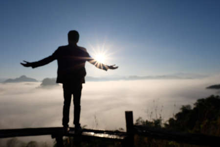Silhouette of man at the beautiful rise on the mountain, In the morning time, Picture for backgroundの写真素材