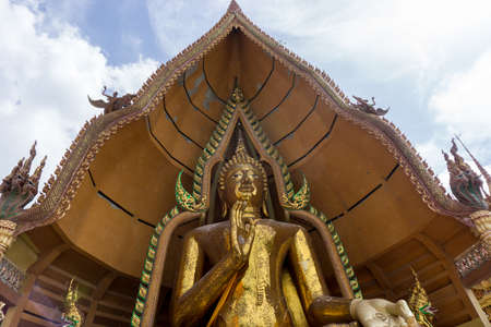 The golden buddha statue in public place of Thai temple on the blue skyの写真素材