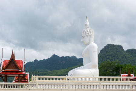 The white buddha statue in public place of Thai temple on the blue skyの写真素材