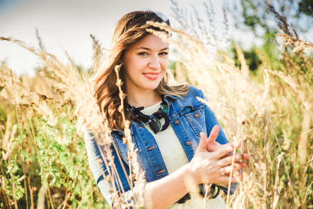beautyful romantic girl with headphones in a wheat field