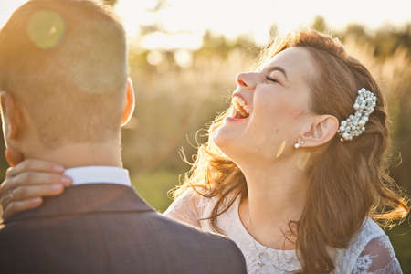 a young bride laughs and yells in the ear of the groomの写真素材