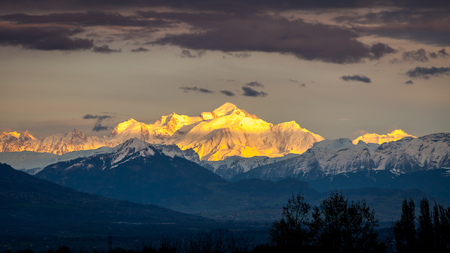 Mont Blanc at sunset. The mountain takes the last sunrays and a golden colorの写真素材