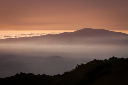Gradient colors at sundown over the clouds with a volcano and mistの写真素材
