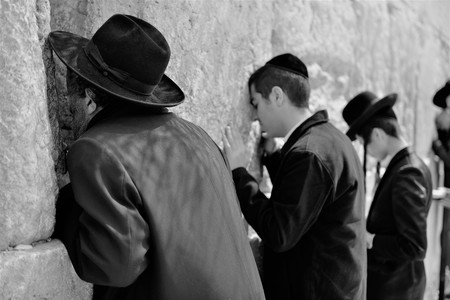 Orthodox hassidic religious jews dressed in black traditional outfit pray at the wailing wall during the high holidays in jerusalem israelの写真素材