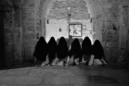 Religious nuns praying in Jesus Christ holy grave church at Christmas in Jerusalemの写真素材