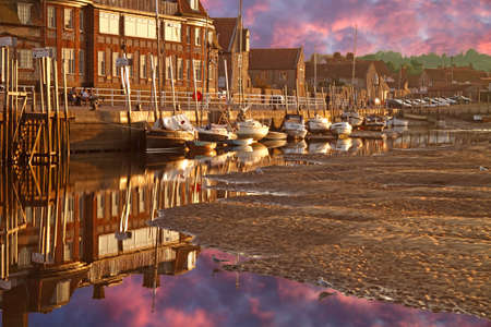 Late evening Summer sun shines on the harbour at Blakeney in Norfolk, England.