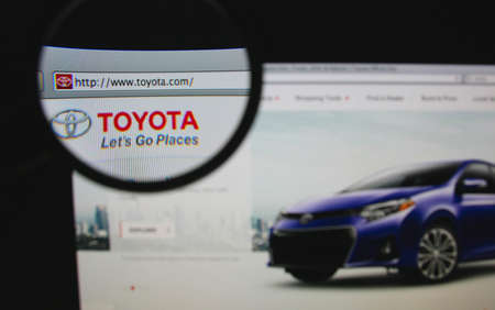 LISBON - JANUARY 22, 2014: Photo of Toyota homepage on a monitor screen through a magnifying glass.のeditorial素材