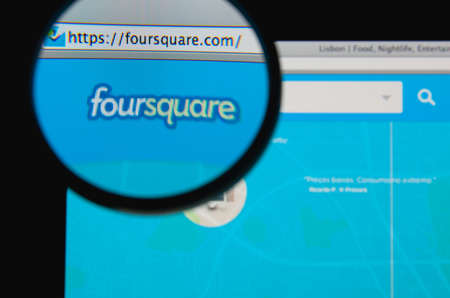LISBON - JANUARY 20, 2014: Photo of Foursquare homepage on a monitor screen through a magnifying glass.のeditorial素材