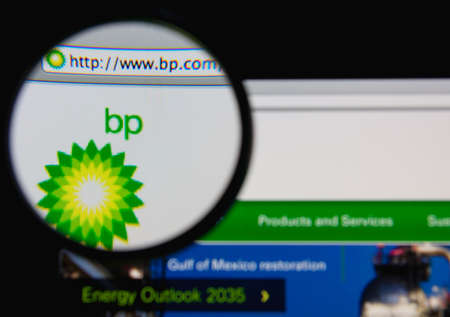 LISBON - JANUARY 20, 2014: Photo of BP homepage on a monitor screen through a magnifying glass.のeditorial素材