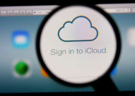 LISBON, PORTUGAL - FEBRUARY 8, 2014: Photo of Icloud homepage on a monitor screen through a magnifying glass.のeditorial素材
