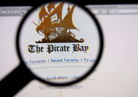 LISBON - JANUARY 14, 2014: Photo of The Pirate Bay homepage on a monitor screen through a magnifying...
