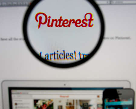 LISBON - JANUARY 14, 2014: Photo of Pinterest homepage on a monitor screen through a magnifying glass.のeditorial素材