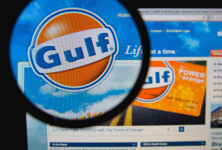 LISBON, PORTUGAL - FEBRUARY 5, 2014: Photo of Gulf Oil homepage on a monitor screen through a magnifying glass.のeditorial素材