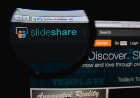 LISBON, PORTUGAL - FEBRUARY 8, 2014: Photo of SlideShare homepage on a monitor screen through a magnifying glass.のeditorial素材