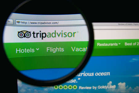LISBON, PORTUGAL - FEBRUARY 19, 2014: TripAdvisor homepage through a magnifying glass.のeditorial素材
