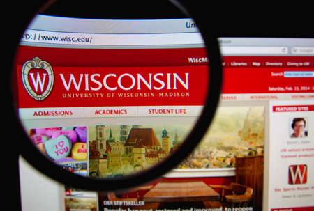 LISBON, PORTUGAL - FEBRUARY 22, 2014: Photo of University of Wisconsin - Madison homepage on a monitor screen through a magnifying glass.のeditorial素材