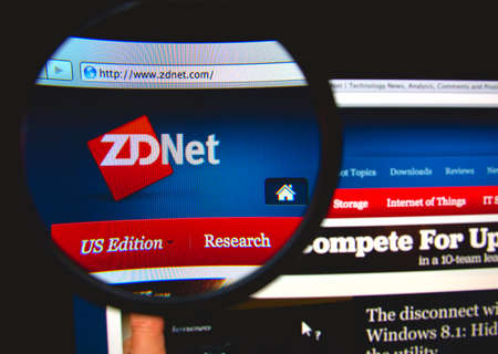 LISBON, PORTUGAL - FEBRUARY 19, 2014: Photo of the ZDNet homepage on a monitor screen through a magnifying glass.のeditorial素材