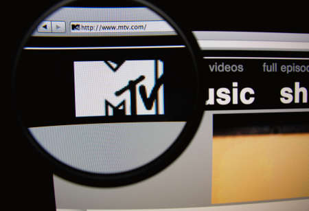 LISBON, PORTUGAL - FEBRUARY 21, 2014: Photo of MTV homepage on a monitor screen through a magnifying glass.のeditorial素材