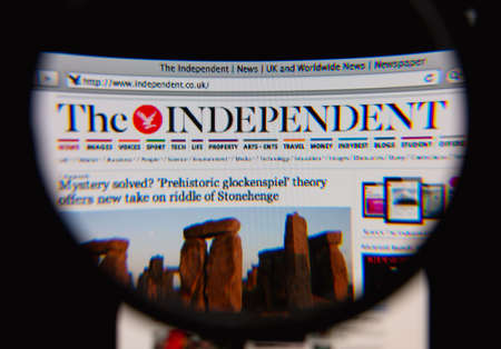 LISBON, PORTUGAL - MARCH 7, 2014: Photo of The Independent homepage on a monitor screen through a magnifying glass.のeditorial素材