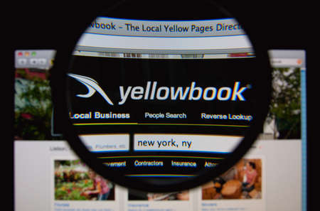 LISBON, PORTUGAL - MARCH 7, 2014: Photo of Yellowbook homepage on a monitor screen through a magnifying glass.のeditorial素材