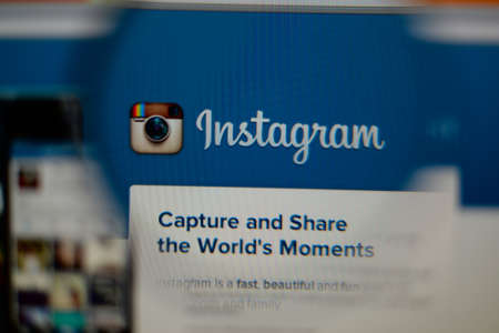 LISBON, PORTUGAL - AUGUST 3, 2014: Photo of Instagram homepage on a monitor screen through a magnifying glass.のeditorial素材