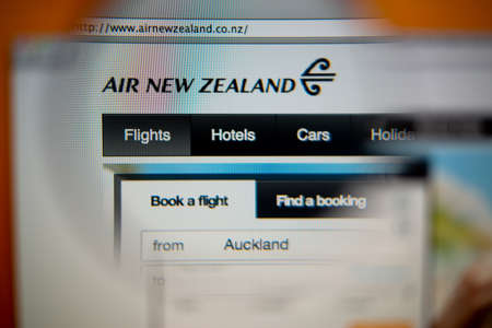 LISBON, PORTUGAL - AUGUST 27, 2014: Photo of Air New Zealand homepage on a monitor screen through a magnifying glass.のeditorial素材