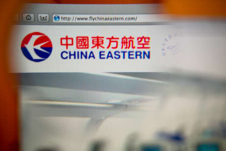 LISBON, PORTUGAL - OCTOBER 27, 2014: Photo of China Eastern Airlines homepage on a monitor screen through a magnifying glass.のeditorial素材