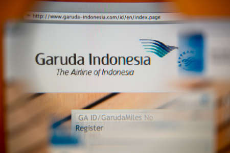 LISBON, PORTUGAL - AUGUST 27, 2014: Photo of Garuda Indonesia homepage on a monitor screen through a magnifying glass.のeditorial素材