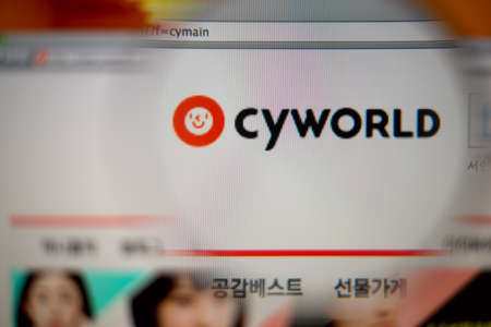 LISBON, PORTUGAL - AUGUST 27, 2014: Photo of Cyworld homepage on a monitor screen through a magnifying glass.のeditorial素材
