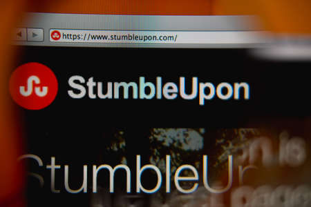 LISBON, PORTUGAL - AUGUST 27, 2014: Photo of StumbleUpon homepage on a monitor screen through a magnifying glass.のeditorial素材