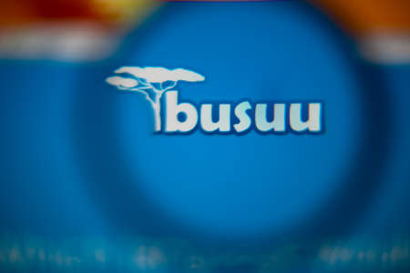 LISBON, PORTUGAL - AUGUST 27, 2014: Photo of Busuu homepage on a monitor screen through a magnifying glass.のeditorial素材