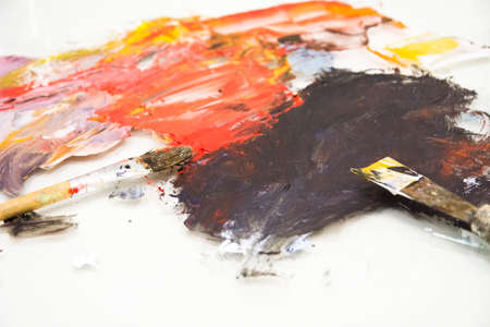 Artist paint brushes on wooden palette. Texture mixed oil paints in different colors. Instruments tools for creative leisure. Painting hobby background. Paintings art concept. Copy space.の写真素材