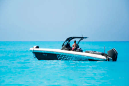 Blurred private small speedboat moored on the shore in Lefkada Island, Greece. Blue sea.の写真素材