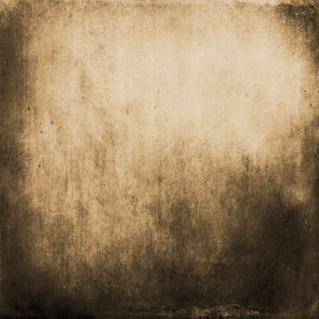 Abstract textured golden or Christmas background with bright center spotlight and black vignette border. With a vintage gold grunge background texture.の写真素材