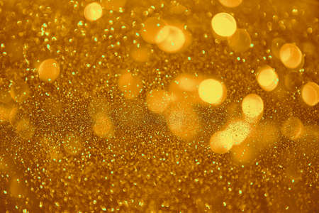 Abstract defocused circular golden luxury gold glitter bokeh lights background. Magic background.  Holiday background. Golden explosion of confetti. Gold Christmas grainy abstract texture.の写真素材