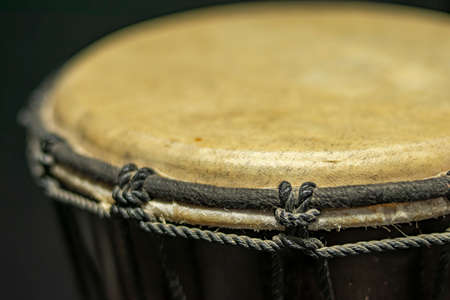 Close-up of a djembe of natural skin of African origin with its tightly fastened tension and tuning stringsの写真素材