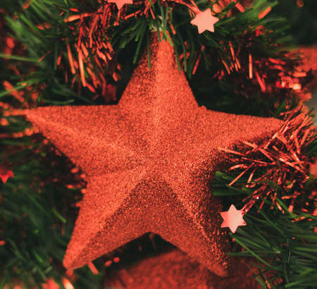 Vintage Christmas decorative star with glitter and green leaves backgroundの写真素材