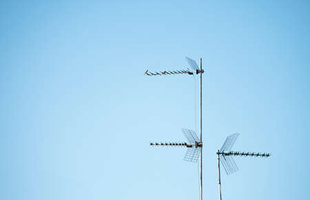 Three television antennas for analog and digital terrestrial television installed on mast on a roof...